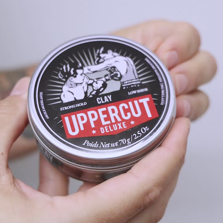 Uppercut Deluxe Clay tin being opened, scooped and spread through hands.