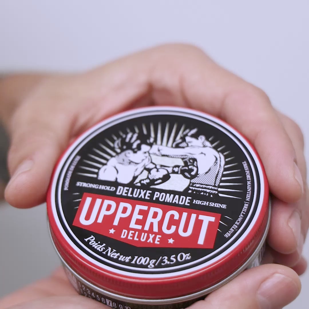 Uppercut Deluxe Pomade tin being opened, scooped and spread through hands.